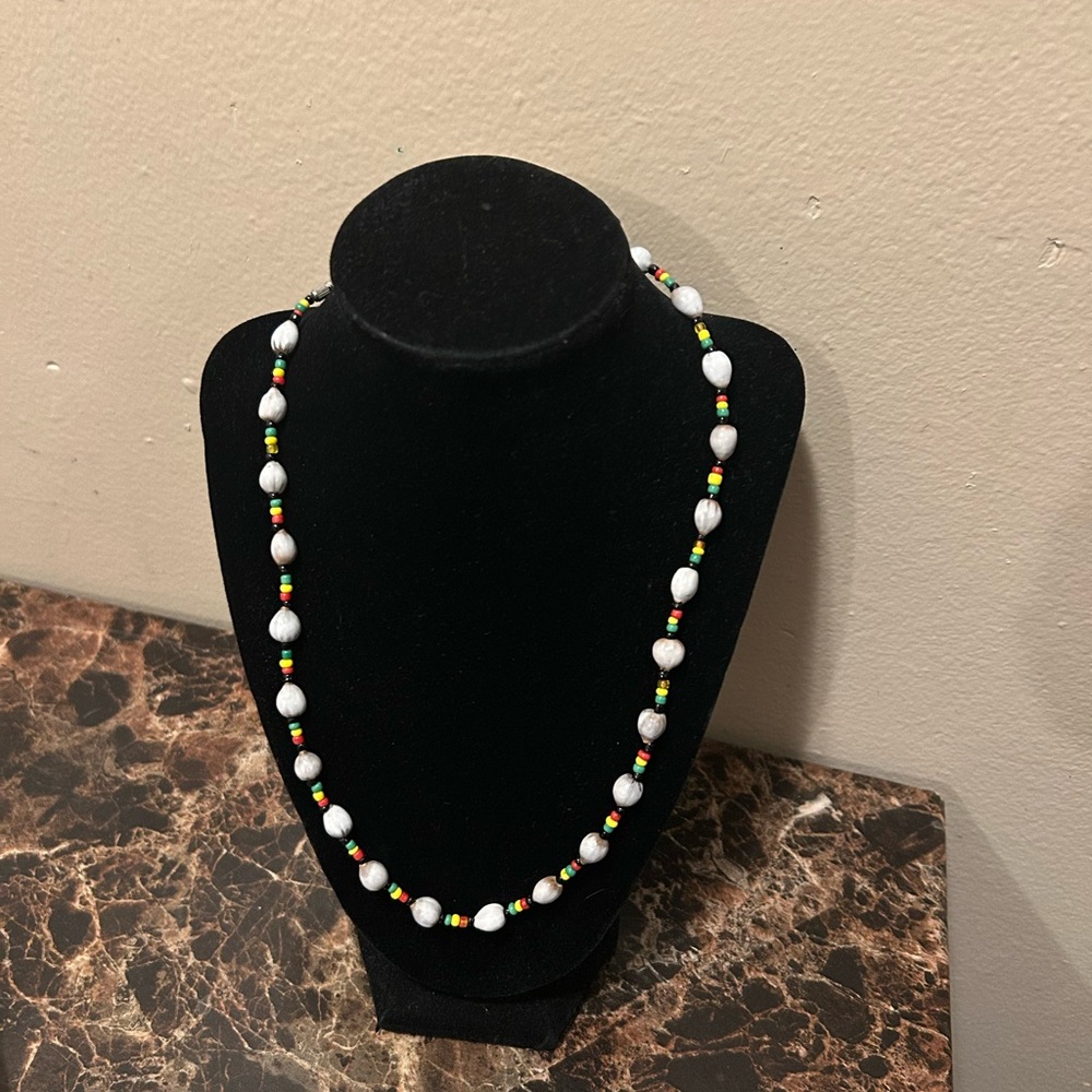 Red, green, yellow, and black beaded necklace with White shell beads